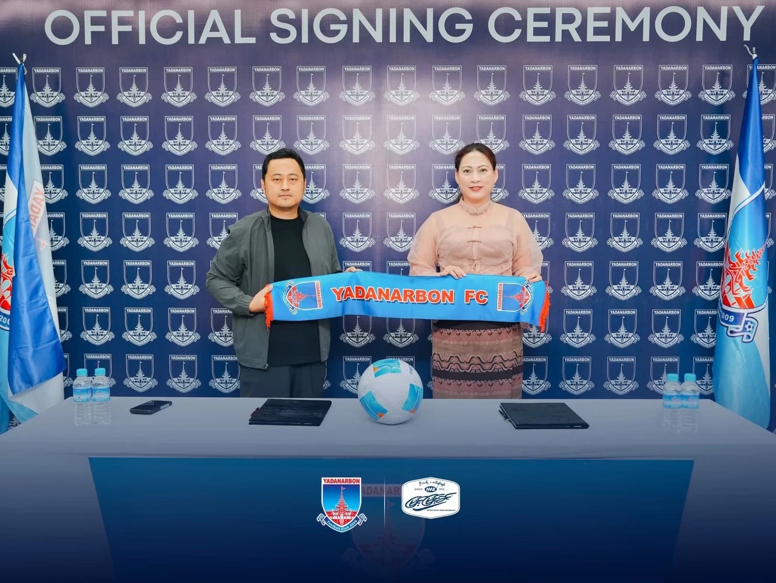 Representatives of Yadanarbon FC and Myint Myint Khin holding a Yadanarbon FC scarf after signing